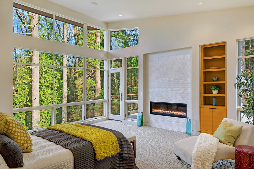 На фото: хозяйская спальня в современном стиле с бежевыми стенами, ковровым покрытием и горизонтальным камином