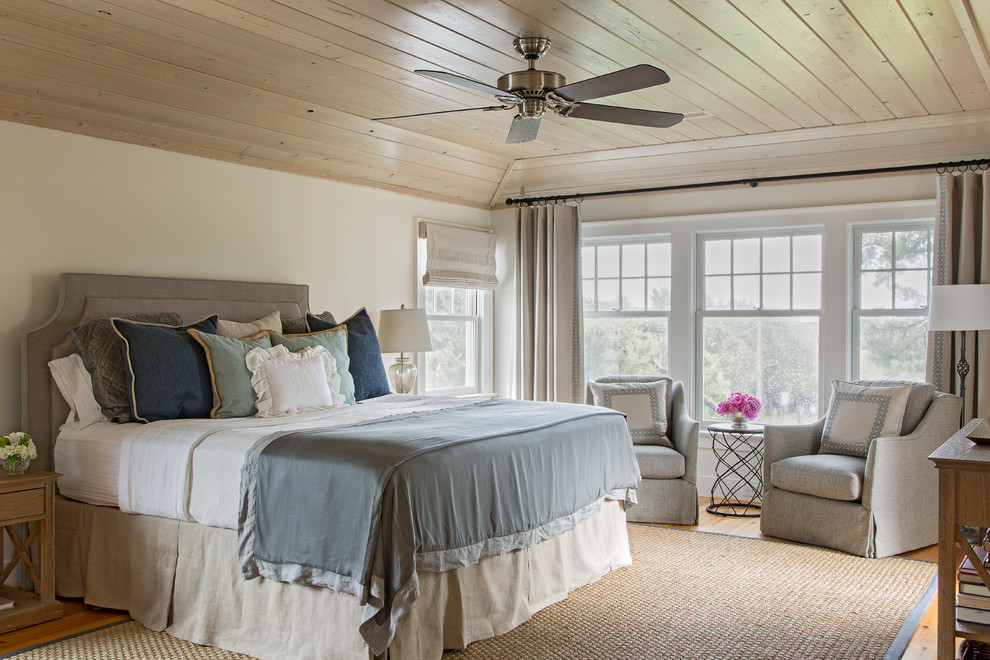 Diseño de dormitorio principal costero grande con paredes blancas y suelo de madera en tonos medios