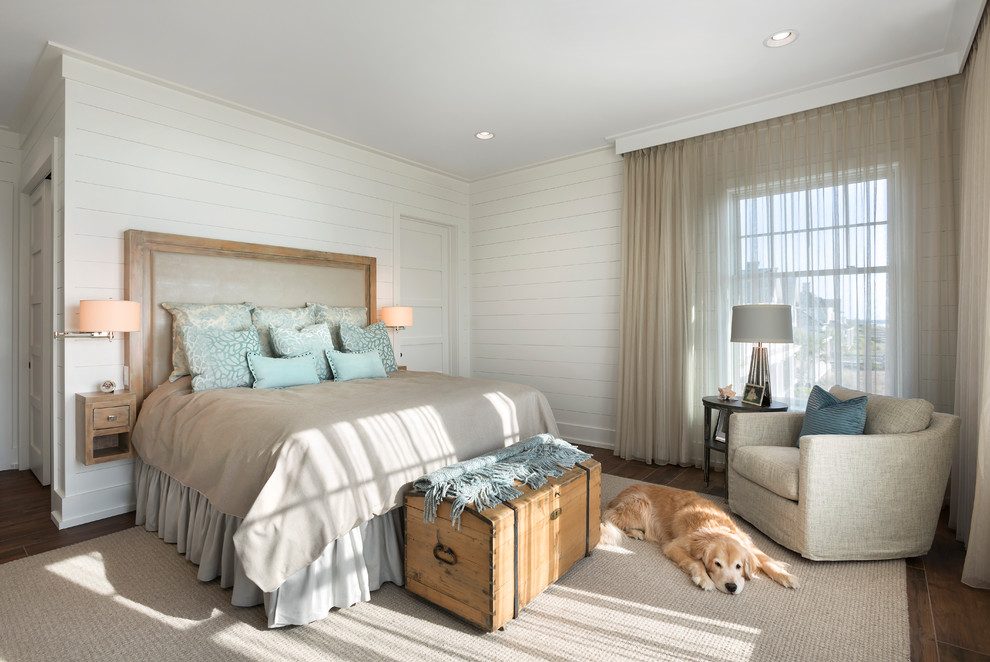 チャールストンにある広いビーチスタイルのおしゃれな主寝室 (白い壁、無垢フローリング、暖炉なし、茶色い床) のレイアウト