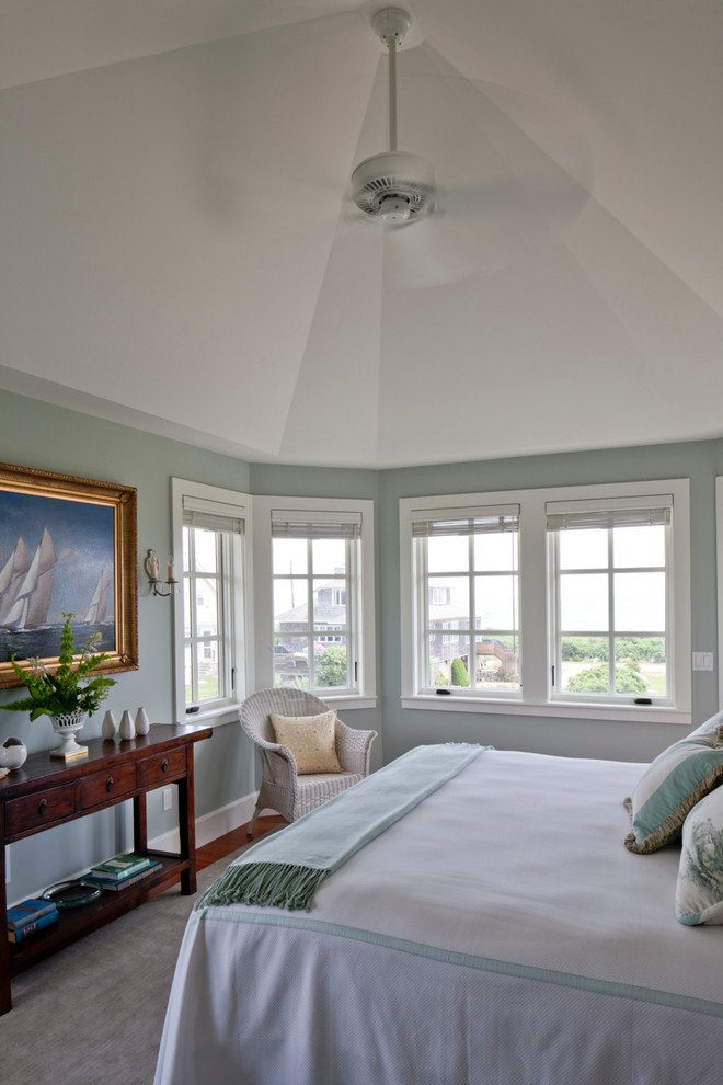 Idées déco pour une grande chambre parentale bord de mer avec un mur vert, un sol en bois brun, aucune cheminée et un sol marron.