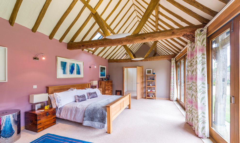Design ideas for a master bedroom in Surrey with pink walls, carpet and beige floors.