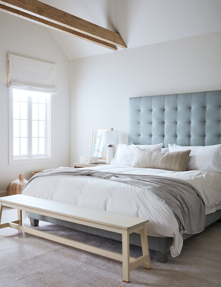 На фото: большая хозяйская спальня в морском стиле с белыми стенами, стандартным камином, фасадом камина из дерева и бежевым полом