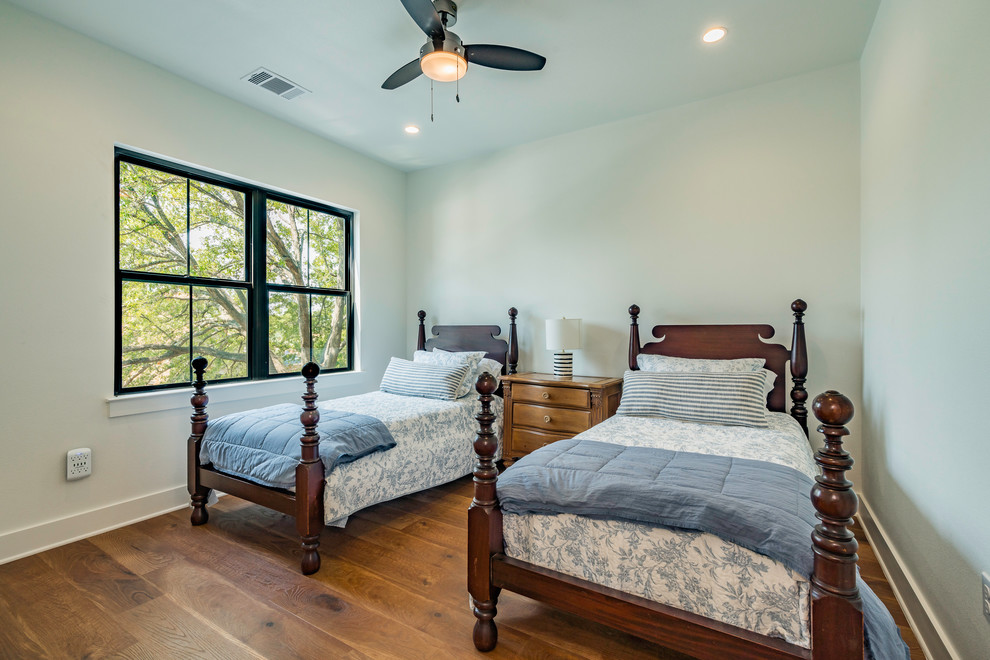 Großes Country Gästezimmer ohne Kamin mit weißer Wandfarbe, braunem Holzboden und braunem Boden in Austin