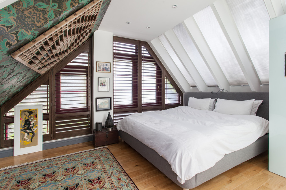 Diseño de dormitorio ecléctico con paredes blancas y suelo de madera clara