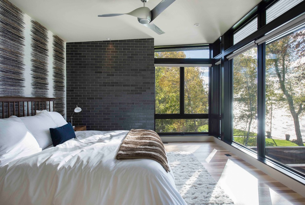 Modernes Schlafzimmer ohne Kamin mit grauer Wandfarbe und hellem Holzboden in Minneapolis