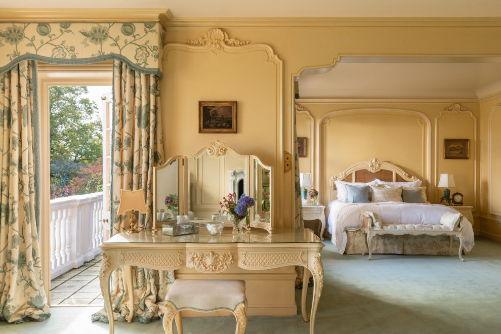 На фото: большая хозяйская спальня в классическом стиле с желтыми стенами, ковровым покрытием и зеленым полом с