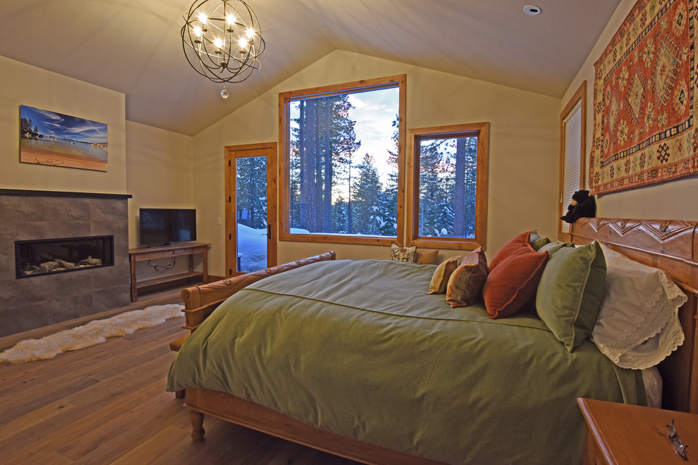 Imagen de dormitorio principal rústico de tamaño medio con paredes beige, suelo de madera oscura, chimenea lineal, marco de chimenea de baldosas y/o azulejos y suelo beige
