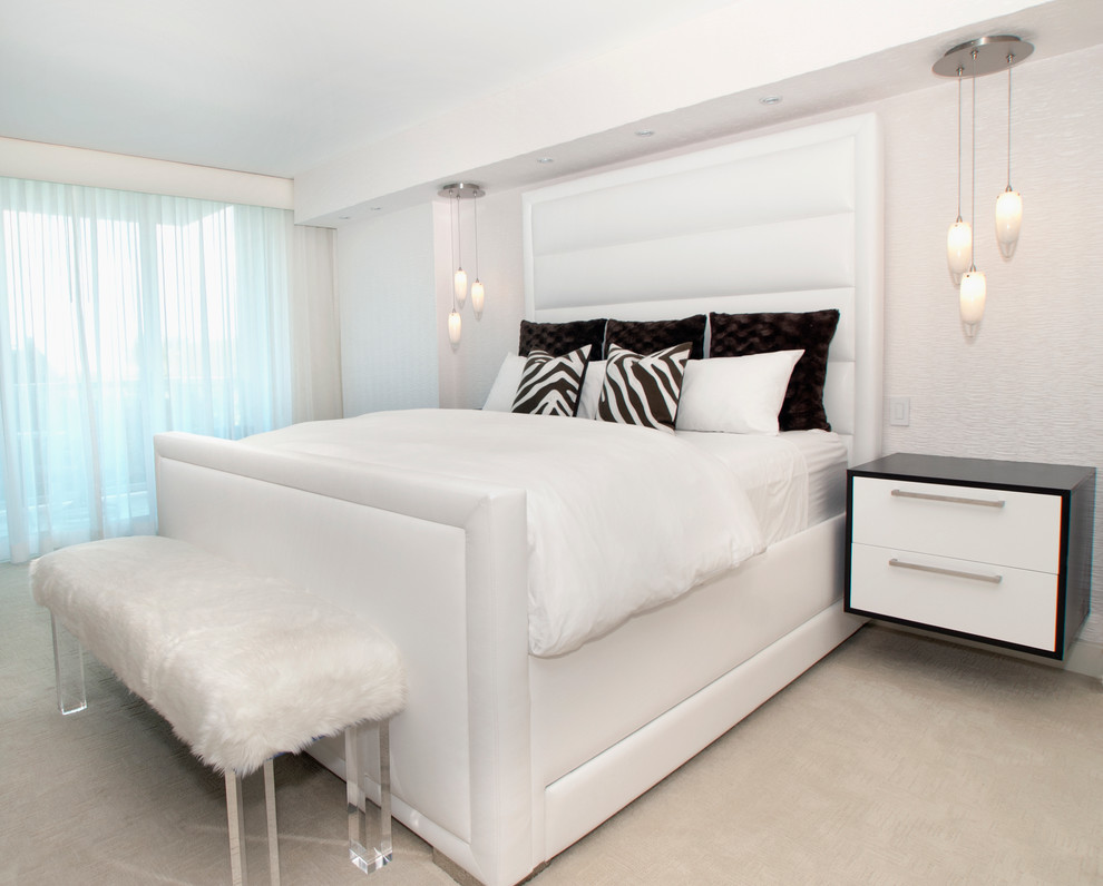 This is an example of a contemporary bedroom in Miami with white walls and carpet.