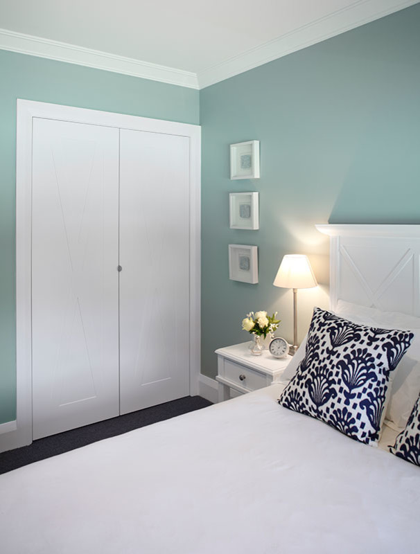 Idee per un'ampia camera degli ospiti chic con pareti blu, moquette e pavimento marrone