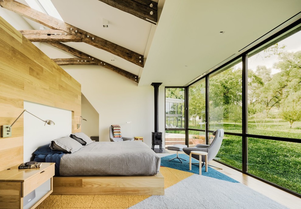 Modernes Hauptschlafzimmer mit beiger Wandfarbe, hellem Holzboden und Kaminofen in San Francisco
