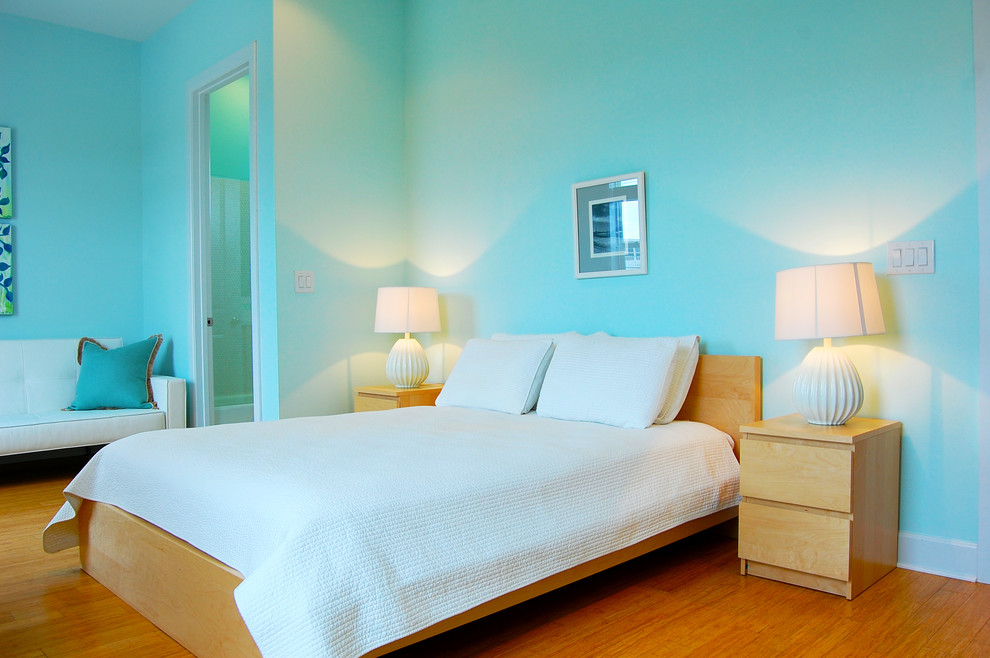 Imagen de dormitorio contemporáneo con paredes azules y suelo de madera en tonos medios