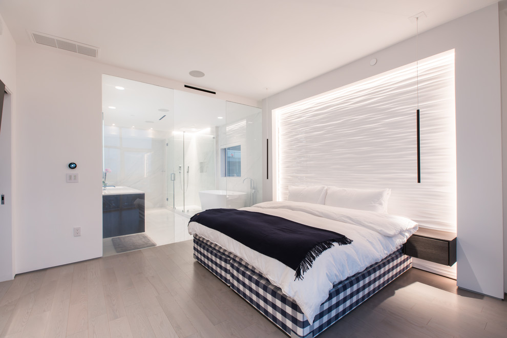 Idee per una camera matrimoniale design con pareti bianche, parquet chiaro e pavimento beige