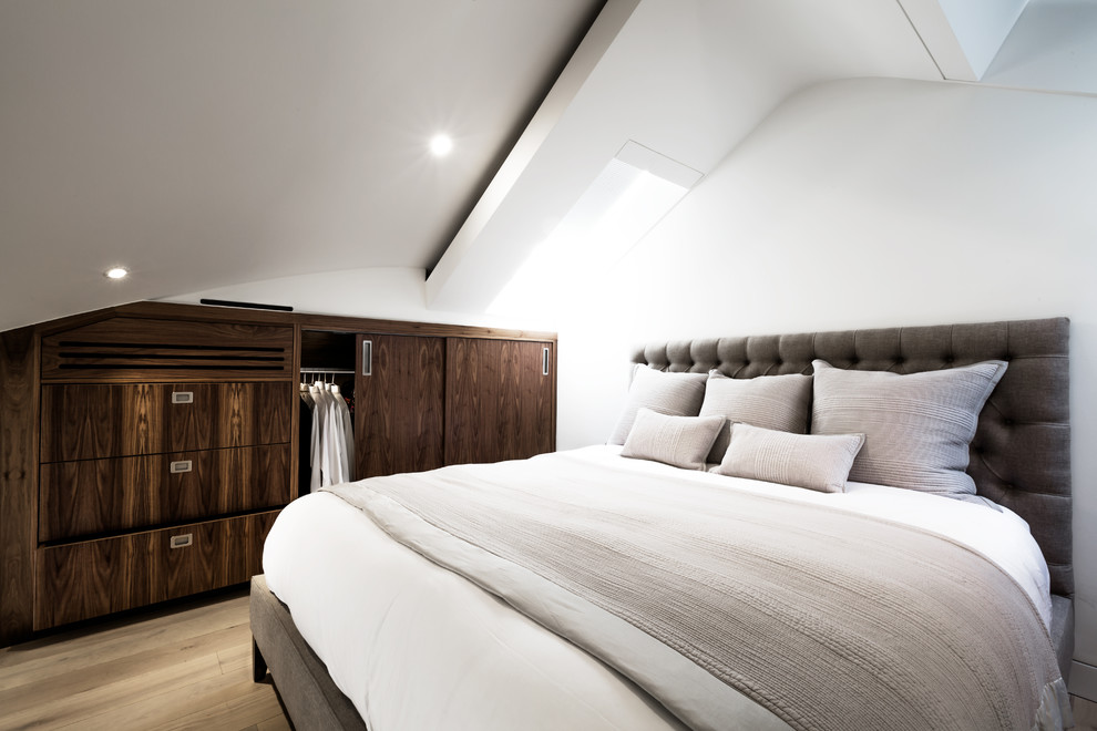 Inspiration for a medium sized contemporary bedroom in London with white walls and light hardwood flooring.