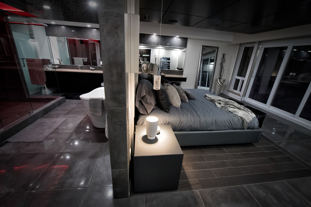 На фото: большая хозяйская спальня в современном стиле с серыми стенами, полом из керамогранита и коричневым полом с