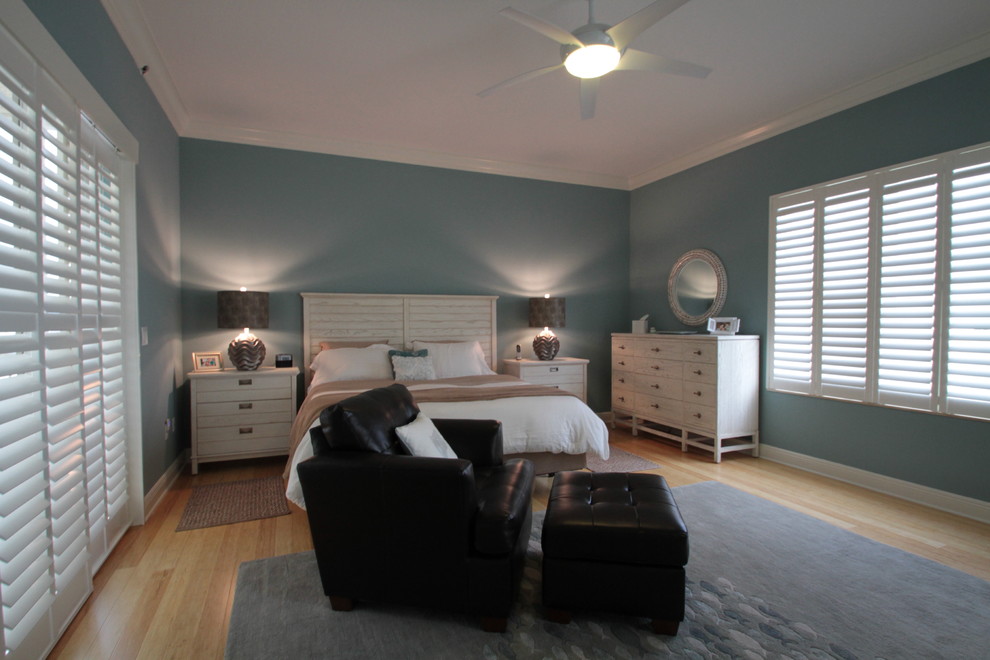 Diseño de dormitorio principal costero de tamaño medio con paredes verdes y suelo de madera clara