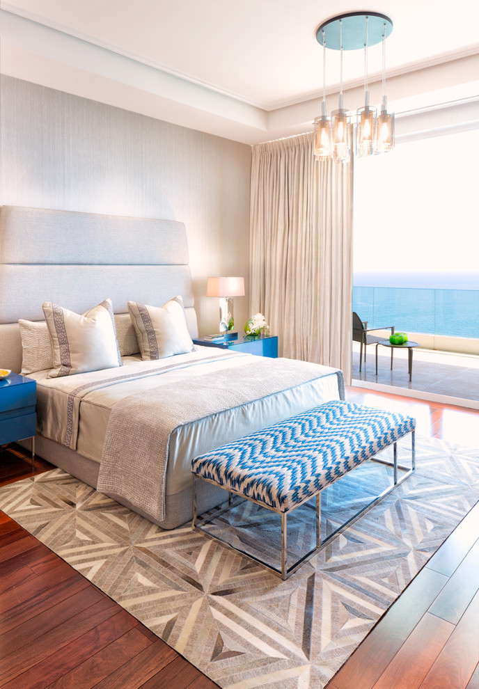Imagen de dormitorio principal costero grande sin chimenea con paredes grises y suelo de madera en tonos medios
