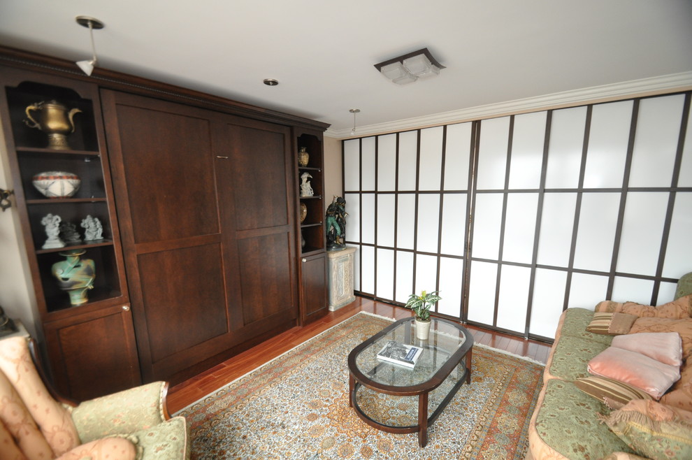 Immagine di una camera degli ospiti eclettica di medie dimensioni con pareti beige, pavimento in legno massello medio e nessun camino