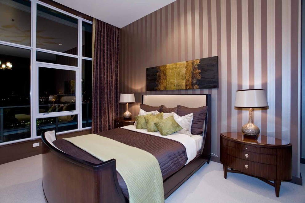 Diseño de dormitorio principal actual de tamaño medio sin chimenea con paredes multicolor, moqueta y suelo beige