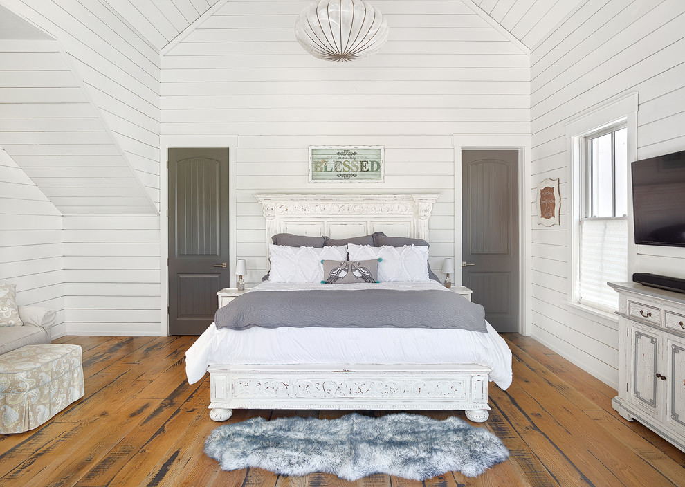 Mittelgroßes Landhausstil Hauptschlafzimmer mit weißer Wandfarbe, hellem Holzboden und braunem Boden in Charleston
