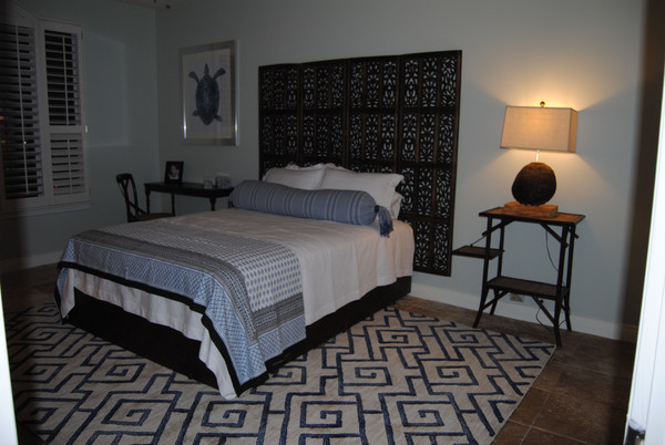 Foto de habitación de invitados tropical sin chimenea con paredes azules y suelo de baldosas de cerámica