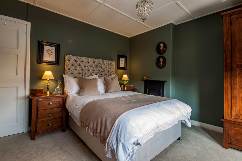 Imagen de dormitorio principal tradicional pequeño con paredes verdes, moqueta, todas las chimeneas, marco de chimenea de metal y suelo beige