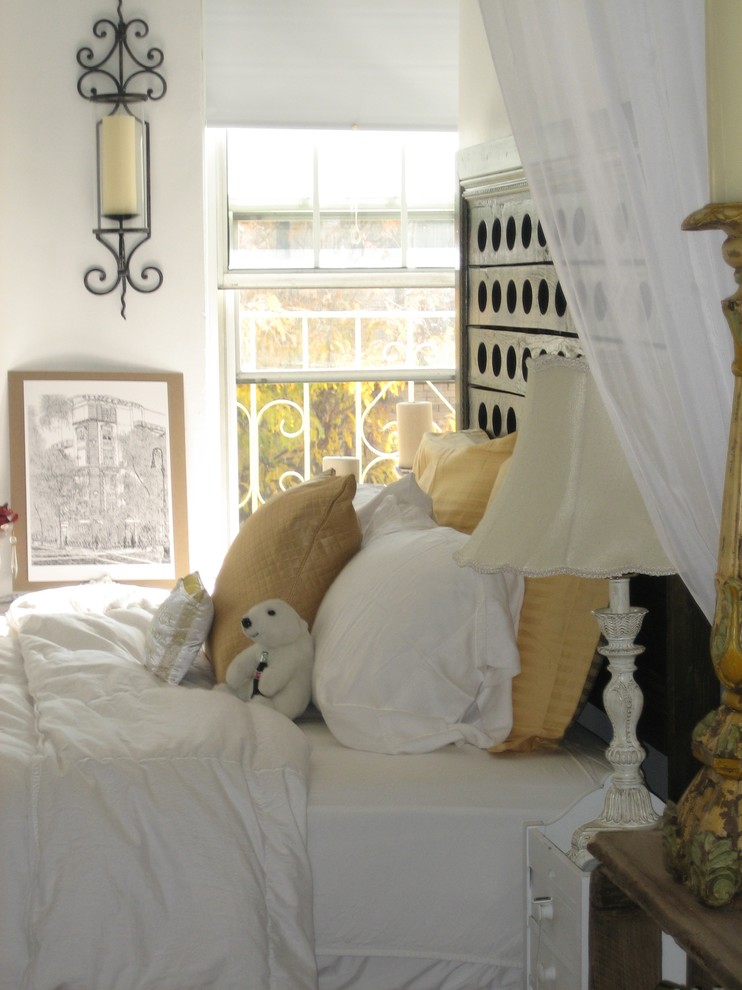 Shabby chic-inspirerad inredning av ett litet sovrum, med vita väggar och mellanmörkt trägolv