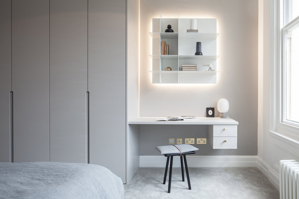 Cette image montre une chambre minimaliste avec un mur gris et un sol gris.