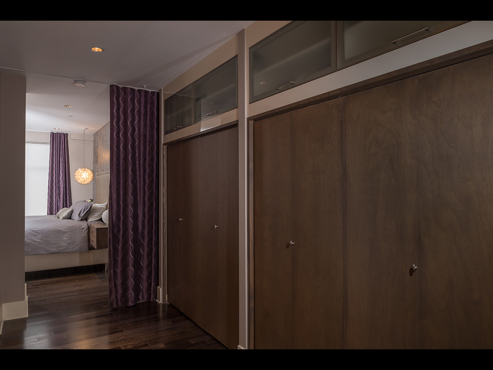 Ejemplo de dormitorio minimalista de tamaño medio con paredes púrpuras y suelo de madera oscura