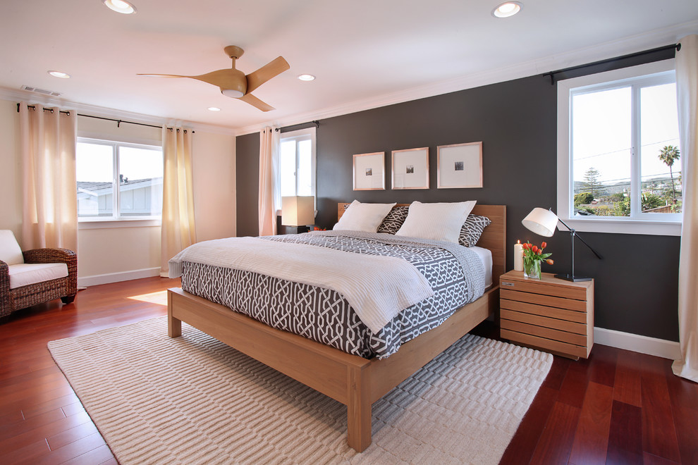 Example of a transitional medium tone wood floor bedroom design in Orange County with black walls and no fireplace