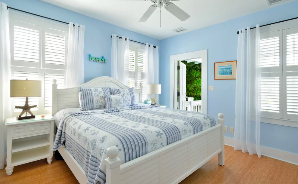 Imagen de habitación de invitados marinera sin chimenea con suelo de madera en tonos medios, suelo marrón y paredes azules