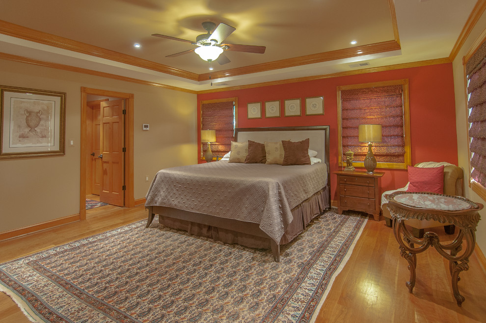 Example of a mid-sized classic master medium tone wood floor bedroom design in DC Metro with red walls and no fireplace