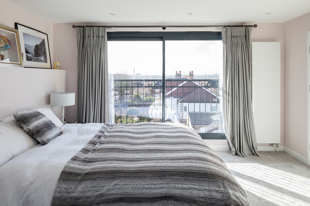Modern master and grey and pink bedroom in London with pink walls, carpet and grey floors.