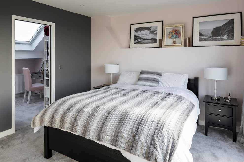 This is an example of a traditional master and grey and pink bedroom in London with pink walls, carpet and grey floors.