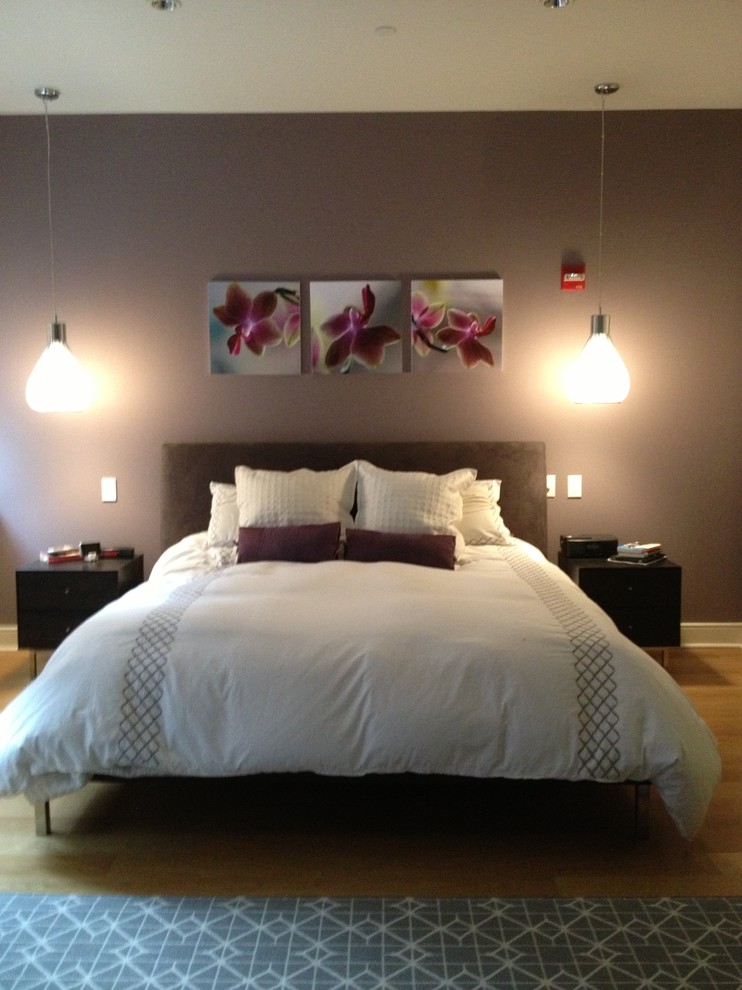 Imagen de dormitorio principal contemporáneo de tamaño medio con paredes púrpuras y suelo de madera clara