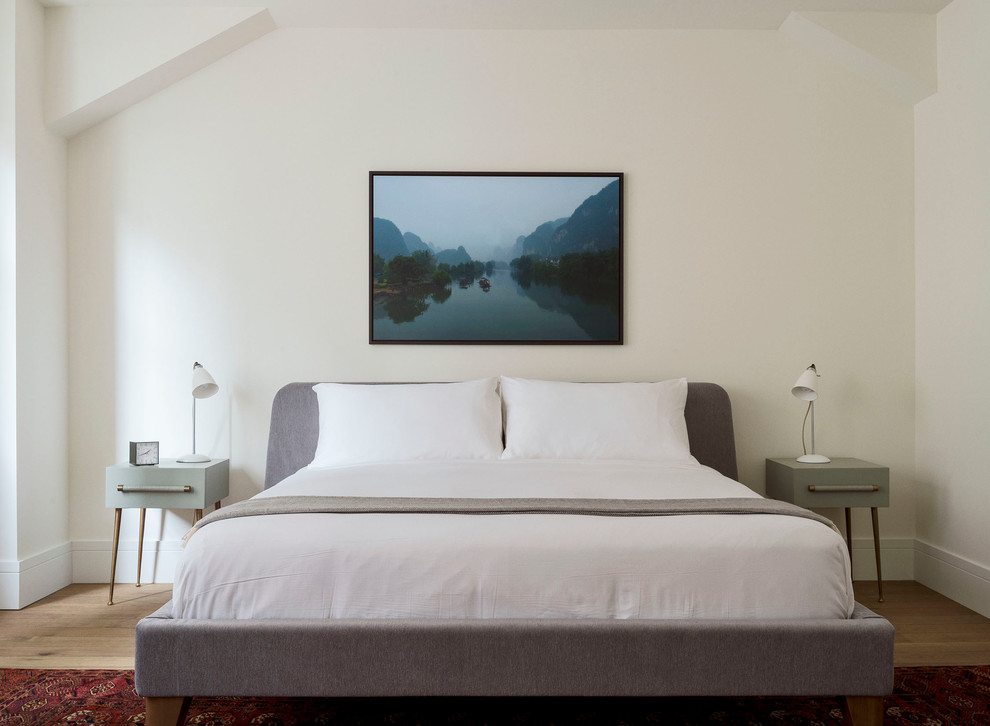 Immagine di una camera da letto tradizionale con pareti beige, pavimento in legno massello medio e nessun camino