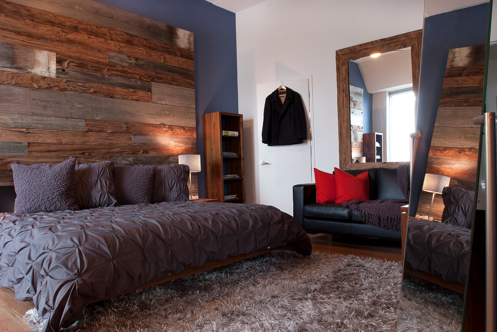 Immagine di una camera da letto design con pareti blu