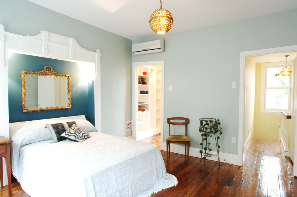 Cette photo montre une chambre éclectique de taille moyenne avec un mur bleu, un sol en bois brun et aucune cheminée.