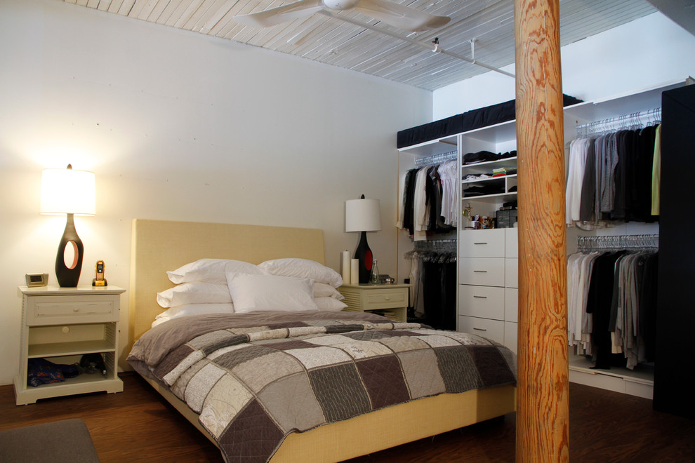 Пример оригинального дизайна: спальня на мансарде в стиле лофт с белыми стенами и темным паркетным полом