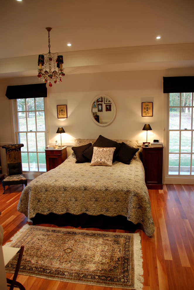 Mittelgroßes Landhausstil Hauptschlafzimmer ohne Kamin mit beiger Wandfarbe und braunem Holzboden in Geelong