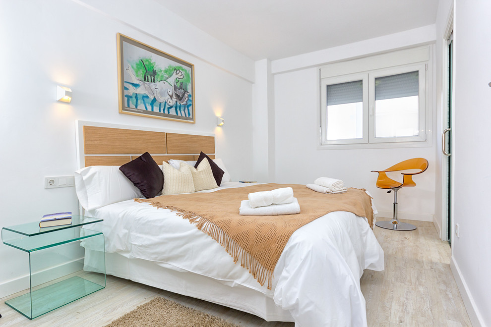 Foto de dormitorio principal mediterráneo de tamaño medio sin chimenea con paredes blancas y suelo de madera clara