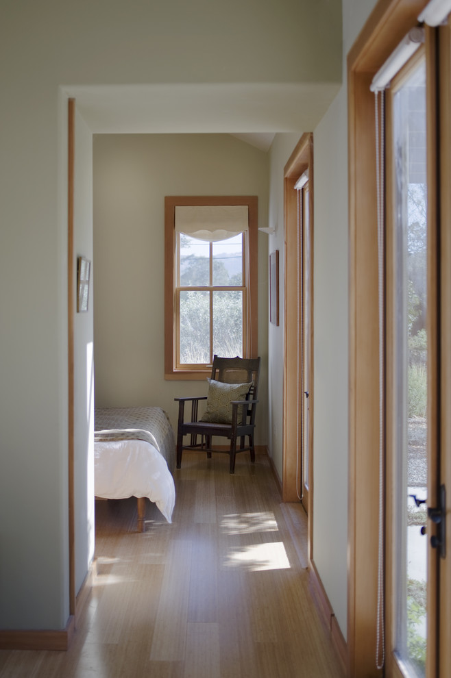 Immagine di una camera da letto contemporanea con pareti grigie e pavimento in legno massello medio