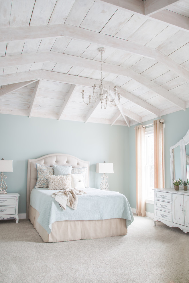 Modelo de dormitorio principal de estilo de casa de campo con paredes azules, moqueta, machihembrado y suelo gris
