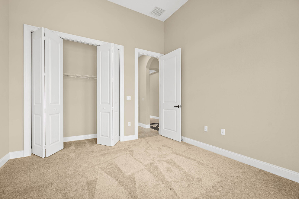 Immagine di una grande camera degli ospiti chic con pareti beige, pavimento con piastrelle in ceramica e pavimento beige
