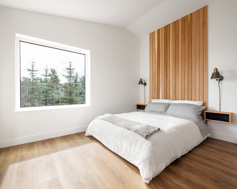 Ispirazione per una camera da letto minimal con pareti bianche, pavimento in legno massello medio, pavimento marrone e soffitto a volta