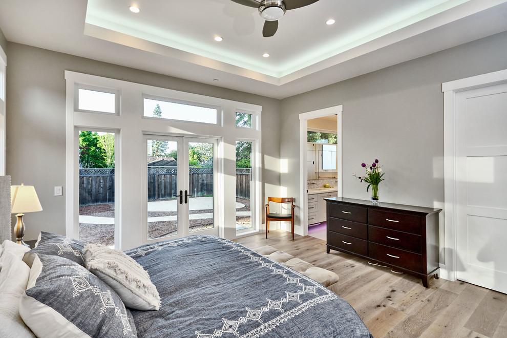 Ejemplo de dormitorio principal clásico de tamaño medio sin chimenea con paredes marrones, suelo de madera clara y suelo marrón