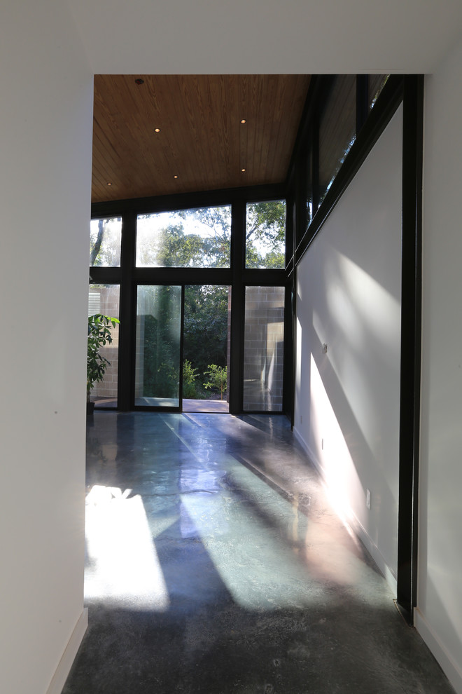 Modern inredning av ett mellanstort huvudsovrum, med vita väggar, betonggolv och grått golv