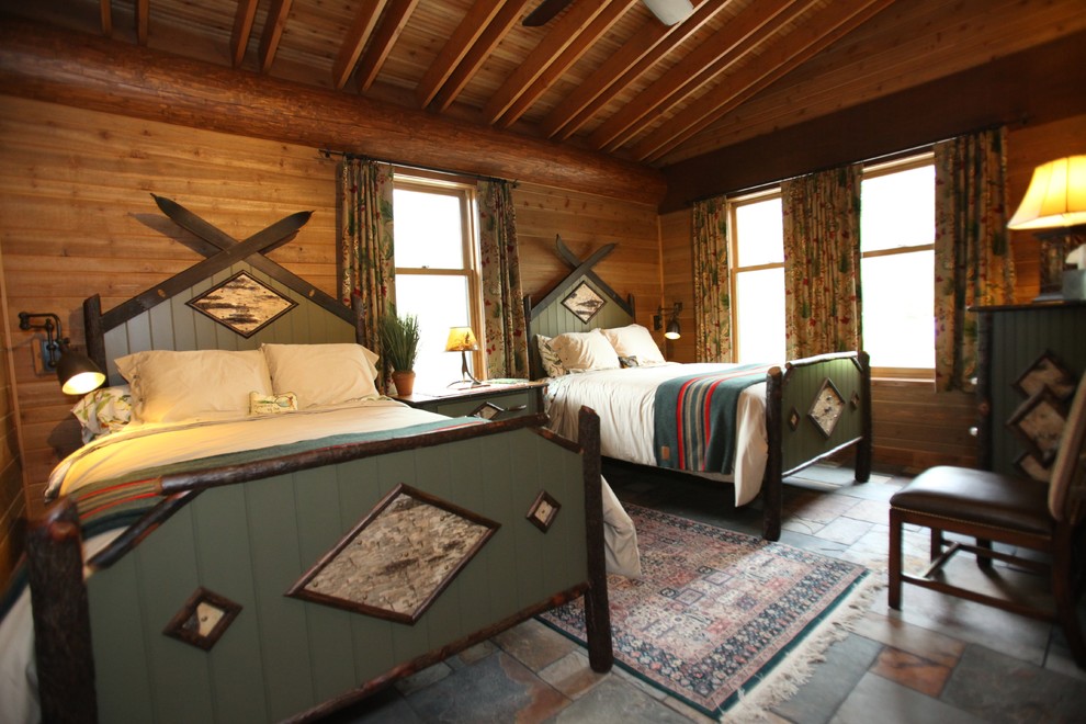 ミネアポリスにある中くらいなラスティックスタイルのおしゃれな客用寝室 (スレートの床、暖炉なし) のインテリア