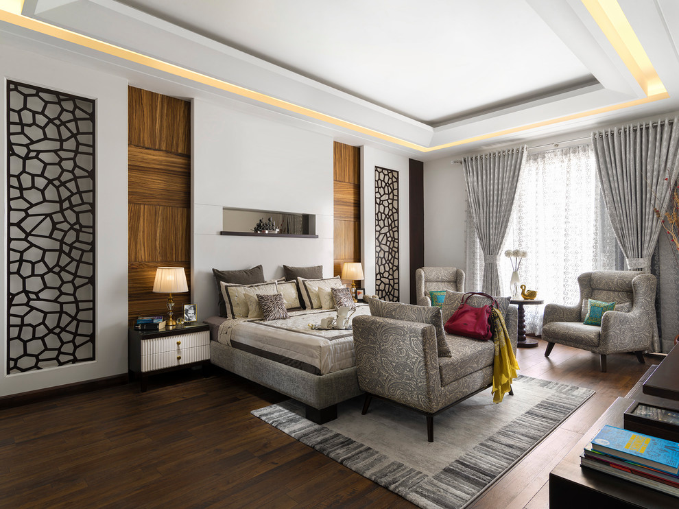 Photo of a modern grey and brown bedroom in Delhi with white walls, dark hardwood flooring and brown floors.