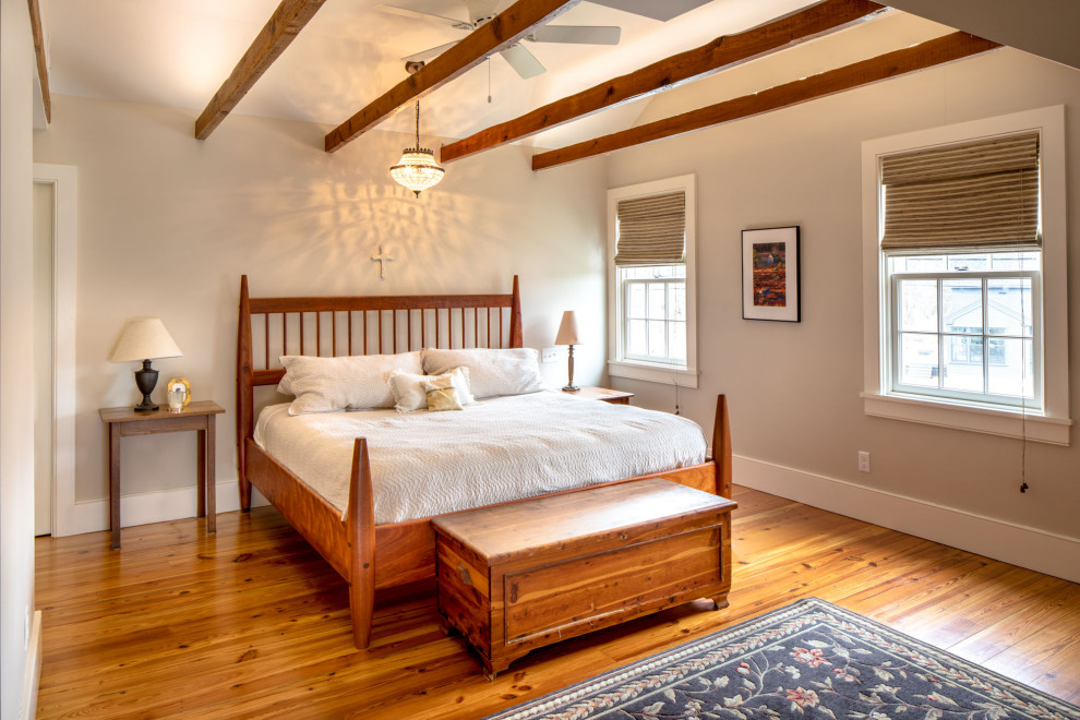 Foto di una camera matrimoniale classica di medie dimensioni con pareti beige, pavimento marrone, pavimento in legno massello medio e travi a vista