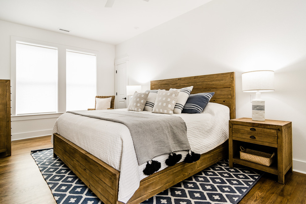 Idéer för ett maritimt sovrum, med vita väggar, mellanmörkt trägolv och brunt golv